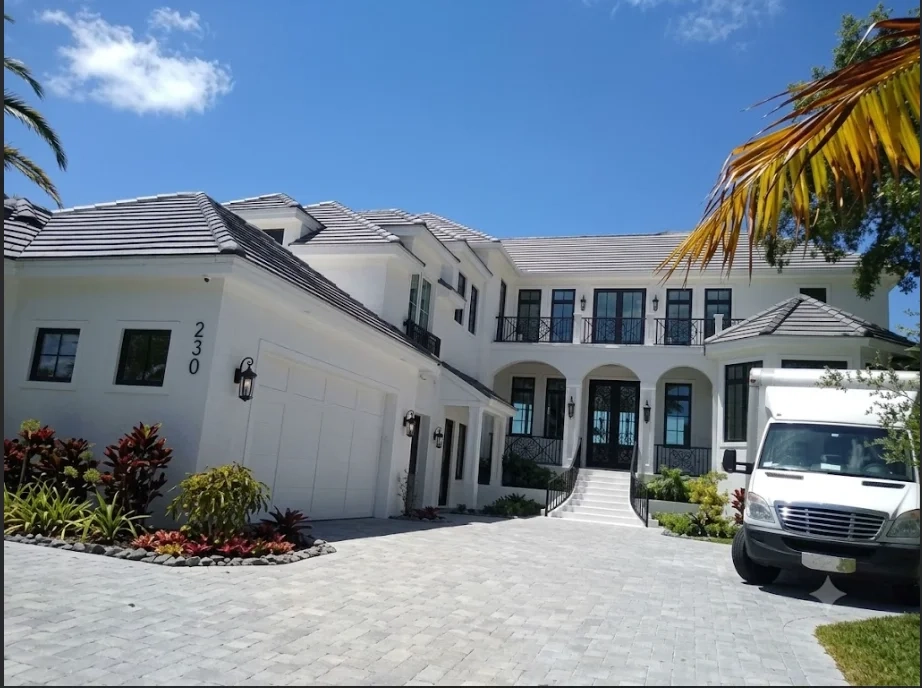 Roofing crew with tools and equipment on a residential roof installation site, demonstrating professional workmanship and safety practices.